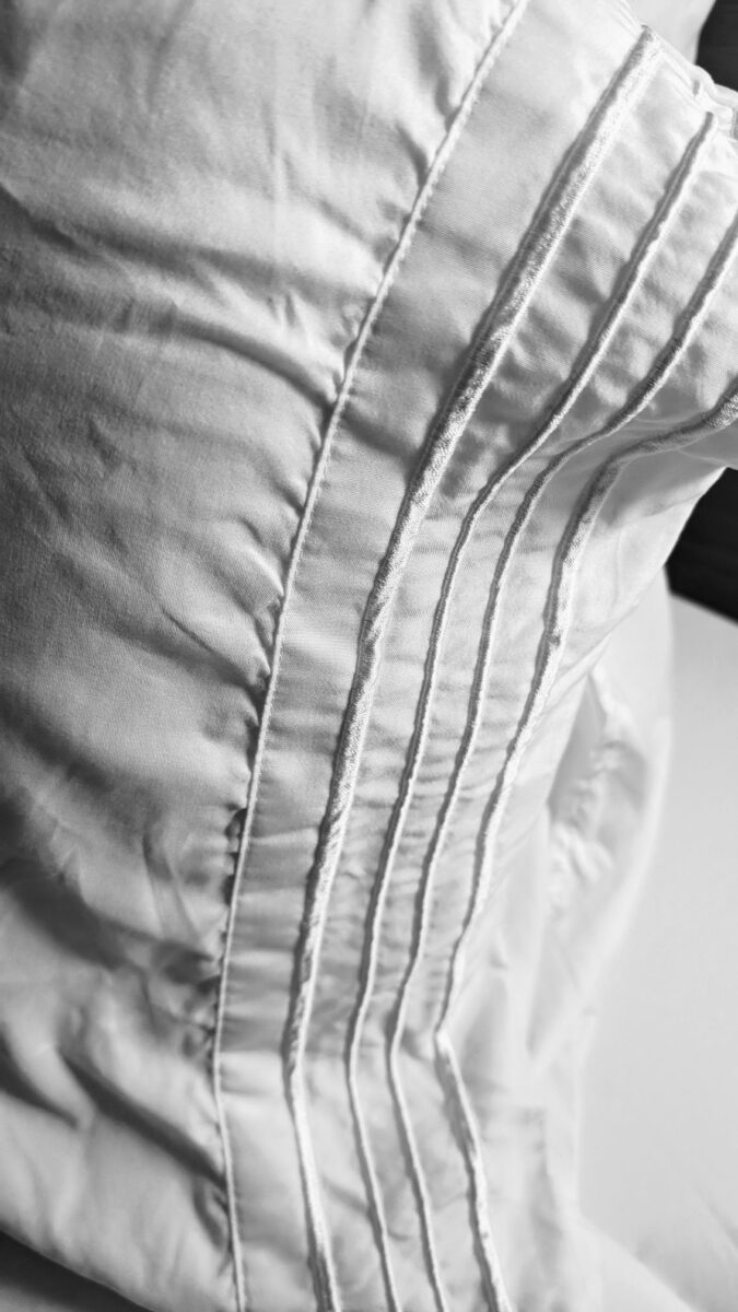 Side of pillow on bed in hotel room