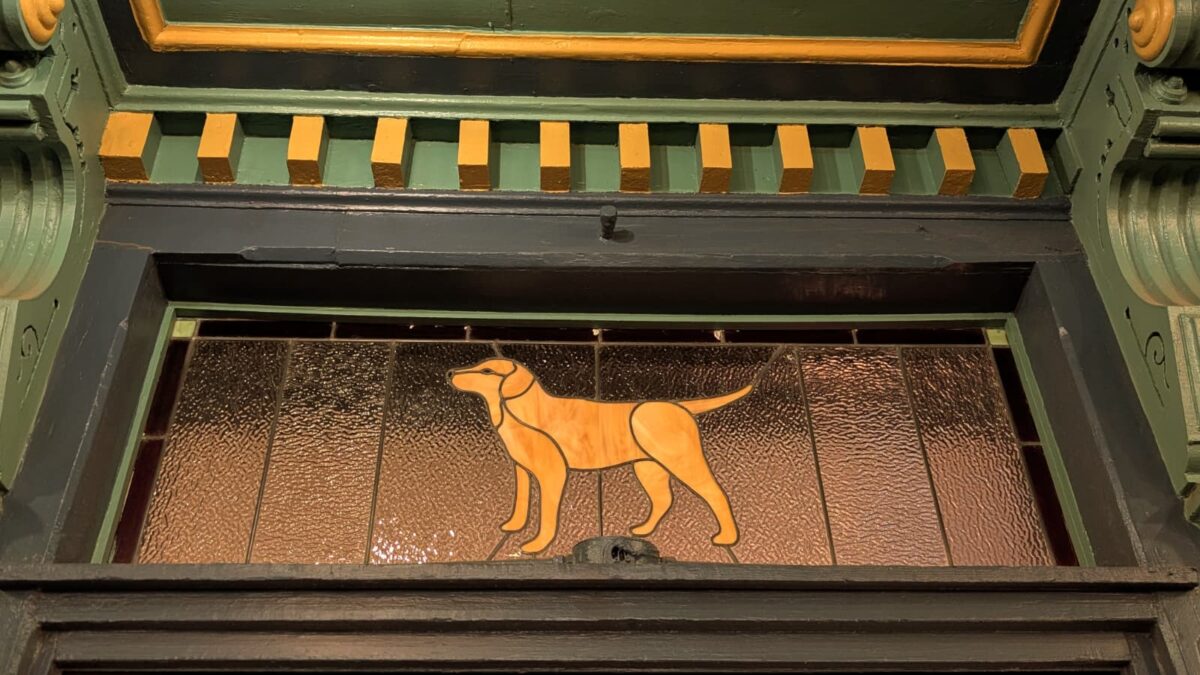 Travel journal image of a stained glass dog at a bar