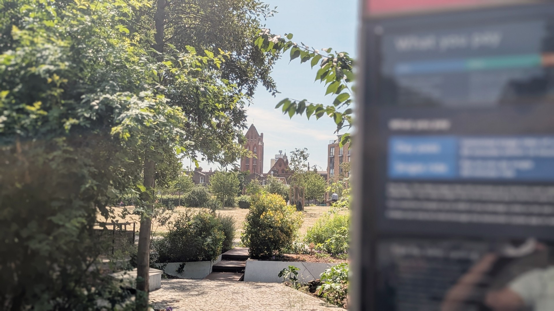 View through Vauxhall Gardens toward brick tower near Santander Cycle stand